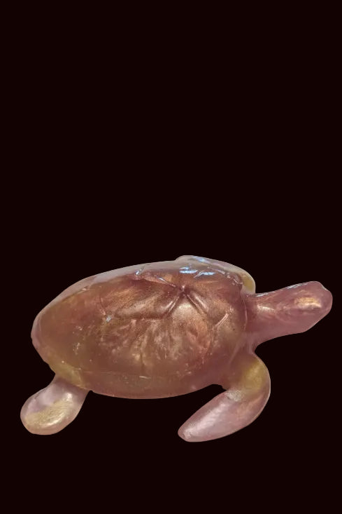 A translucent amber-colored resin sea turtle figurine with a glossy finish