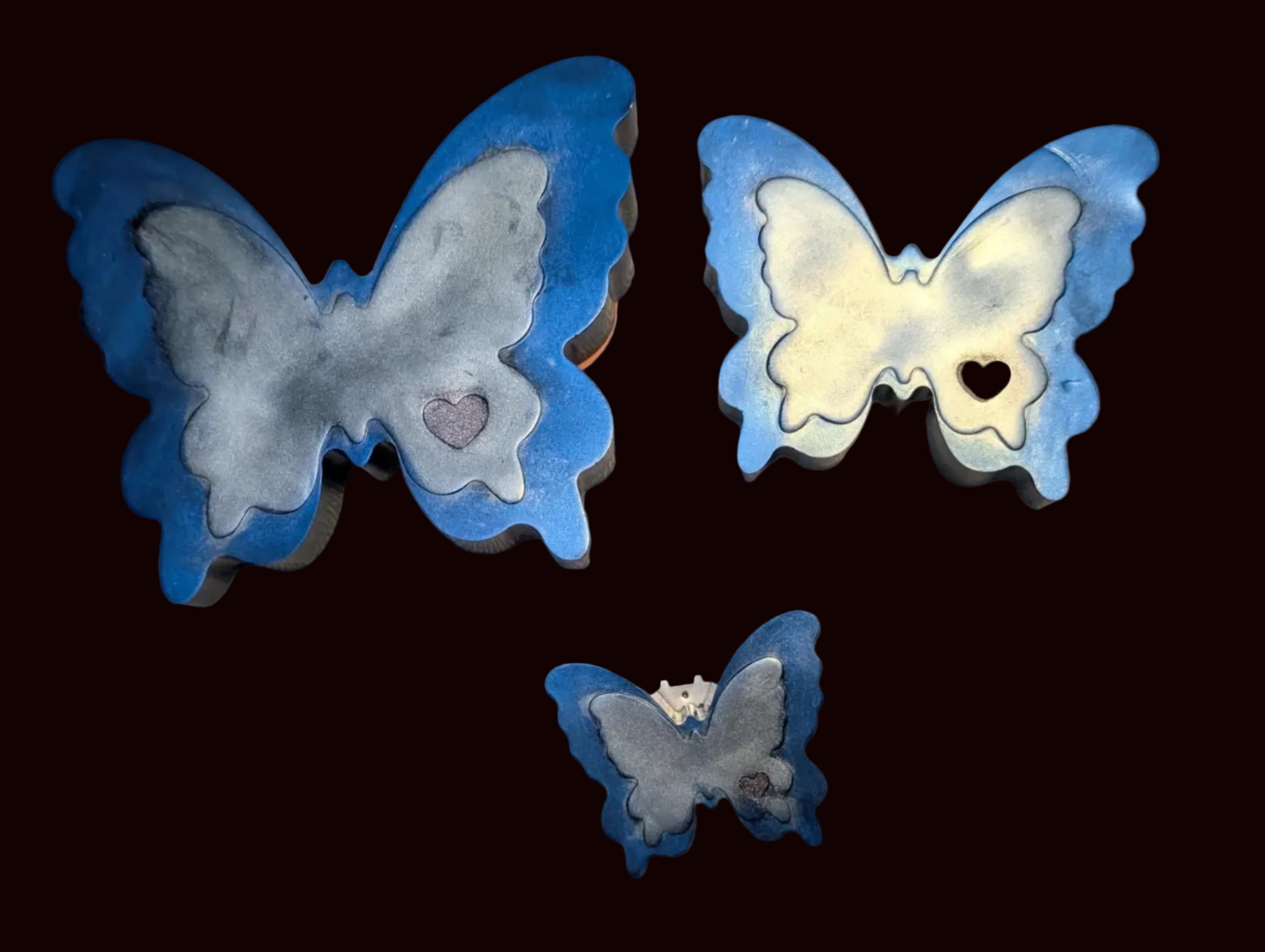 Three butterfly-shaped resin keepsakes with blue borders and silver marbled centers